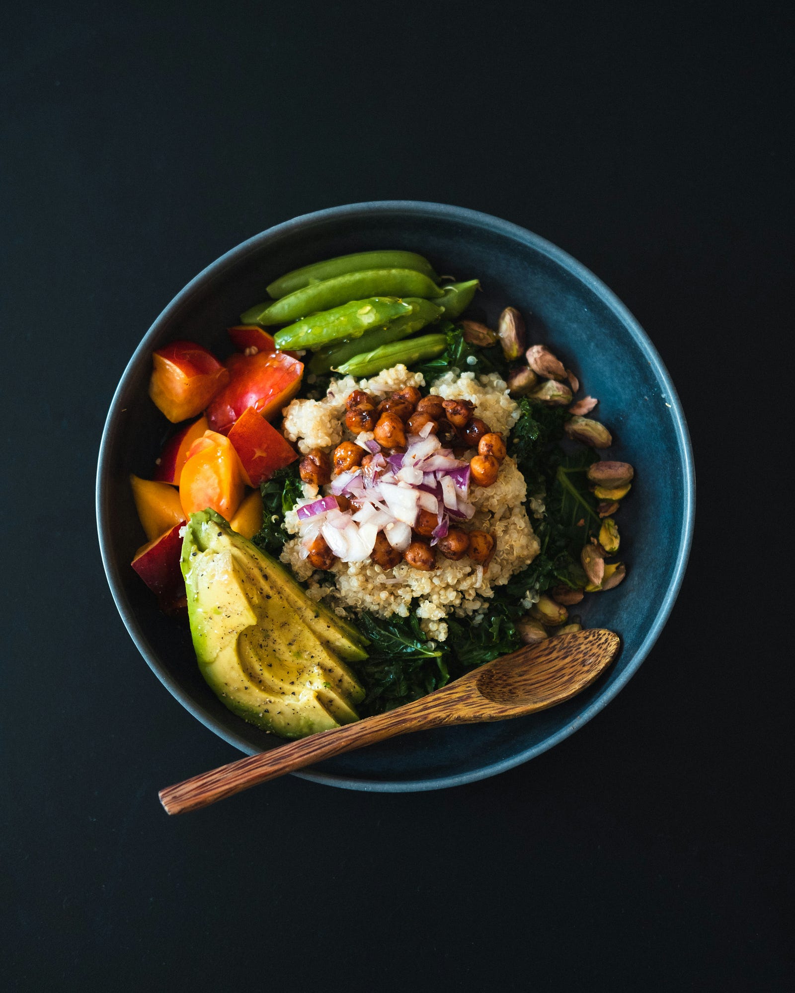 A blue bowl is full of multicolored salad. We see the salad from above.