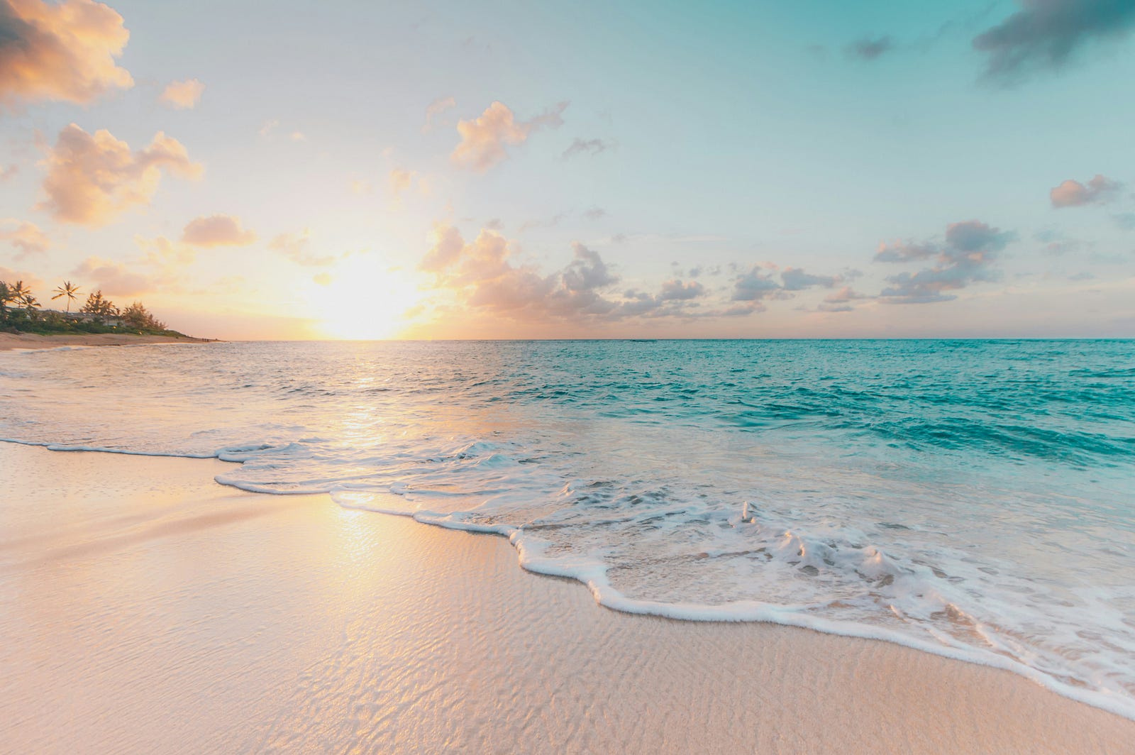 A beach with an aquamarine ocean to the right. Ocean water has a fractal pattern that is pleasing to the human brain.