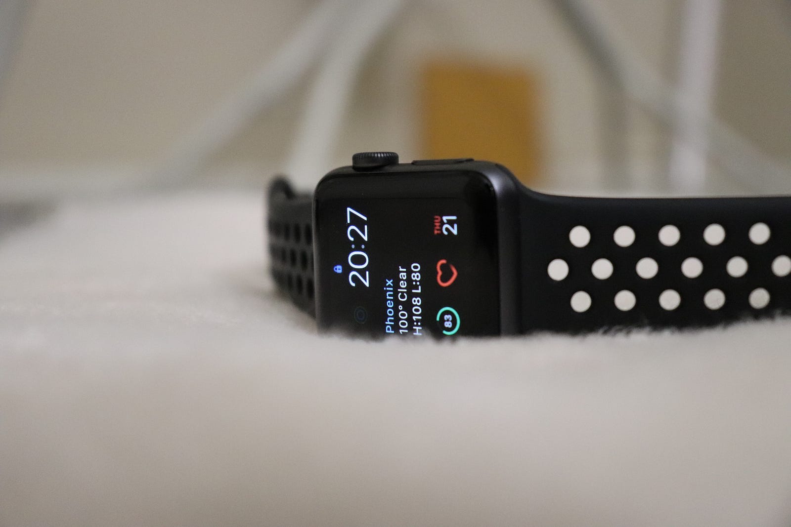 An Apple watch lies on a white blanket, the watch face illuminated and facing the viewer. Many with resting heart rates above 80 will see their pulse drop with physical activity.