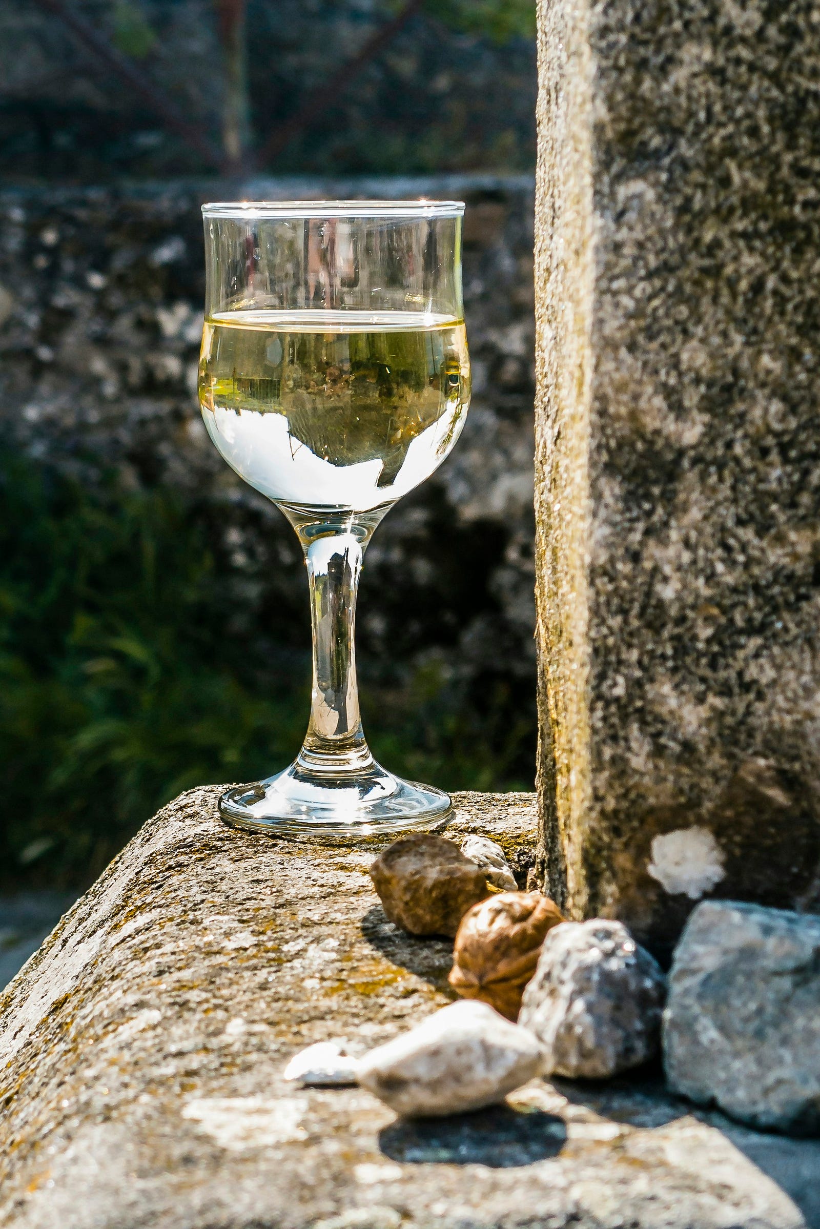 An old-fashioned flass holds white wine.