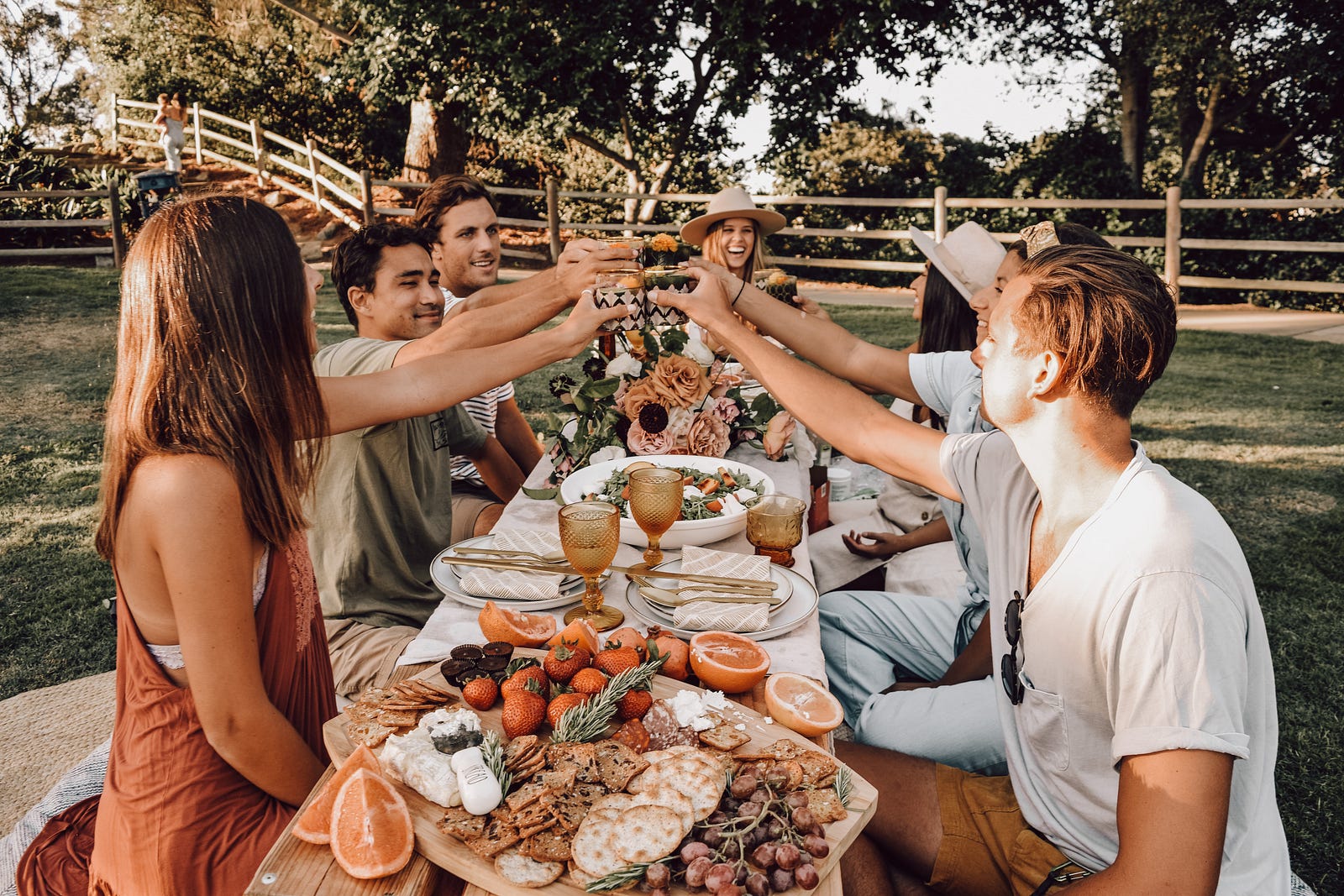 A group of young people raise their glasses —  to toast one another —  over a long dinner table. Loneliness, on the other hand, has been associated with adverse health outcomes comparable to the impact of smoking or obesity.