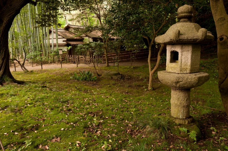 A stone lantern and traditional Japanese building at Yokohama’s Sankei-en gardens