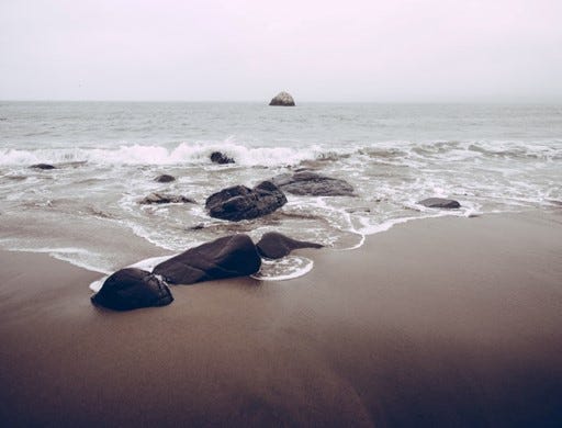Una playa con rocas grandes.