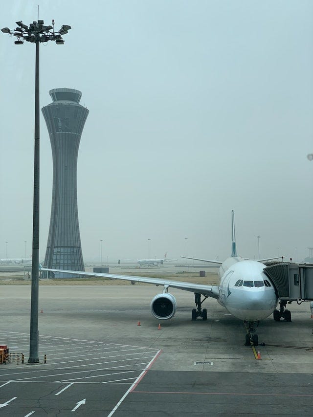 Airplane at at gate with the Air traffic control tower in the background