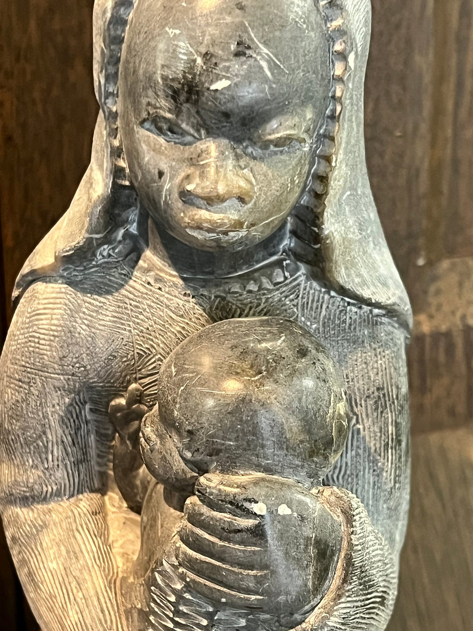 Photo of a black Madonna and child taken at Holy family Retreat Center in West Hartford, CT. The statue is made of black stone that reveals a white chalky interior were carved. The Madonna’s dress is richly texturedwith fine gomatrical lines.