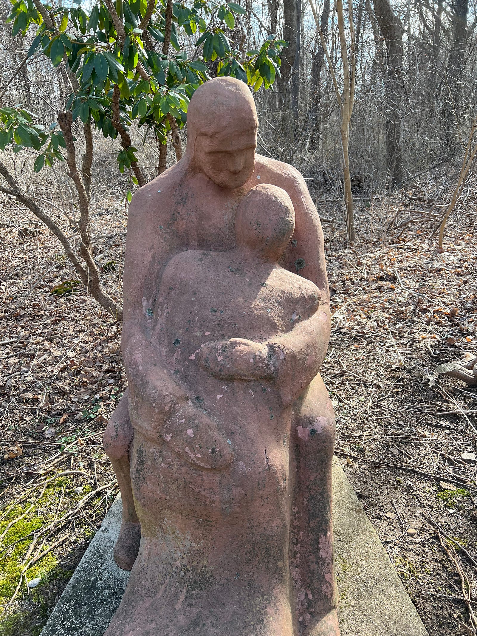 Statue of the father embracing the prodigal son in an outdoor garden.