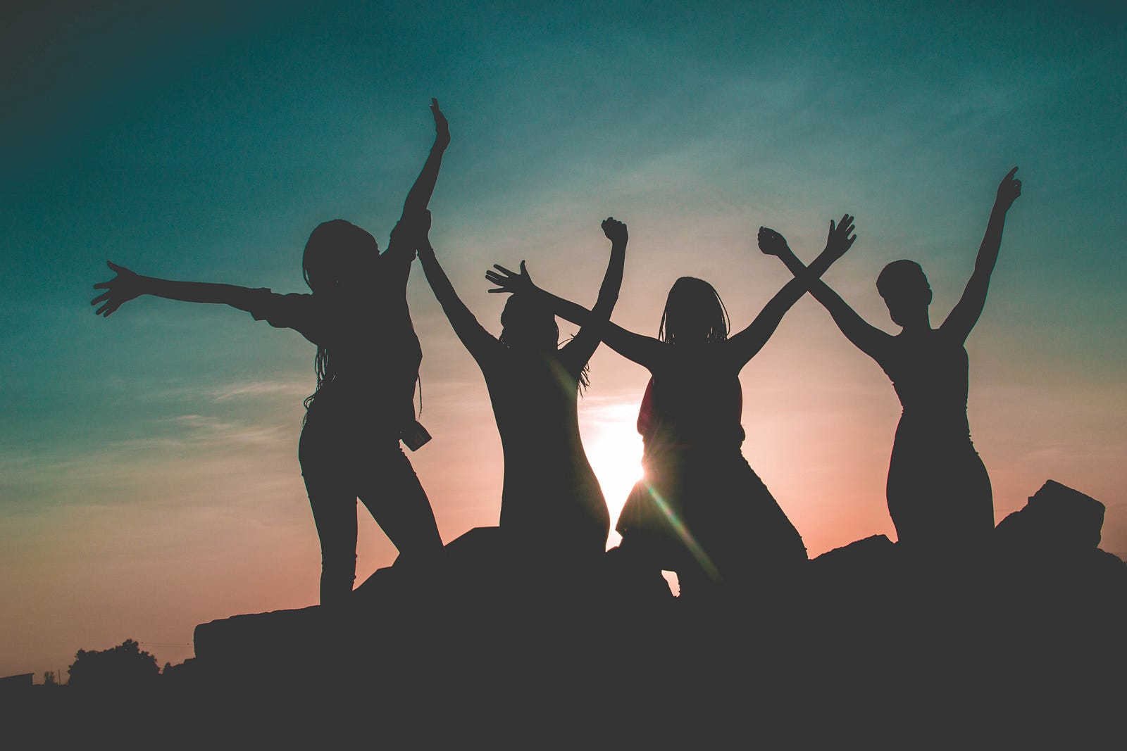 4 women in show with arms in the air
