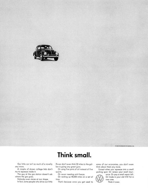 small black Volkswagon beatle car in top left of blank fill page ad with text in 3 columns at the very bottom. Text reads Think small.