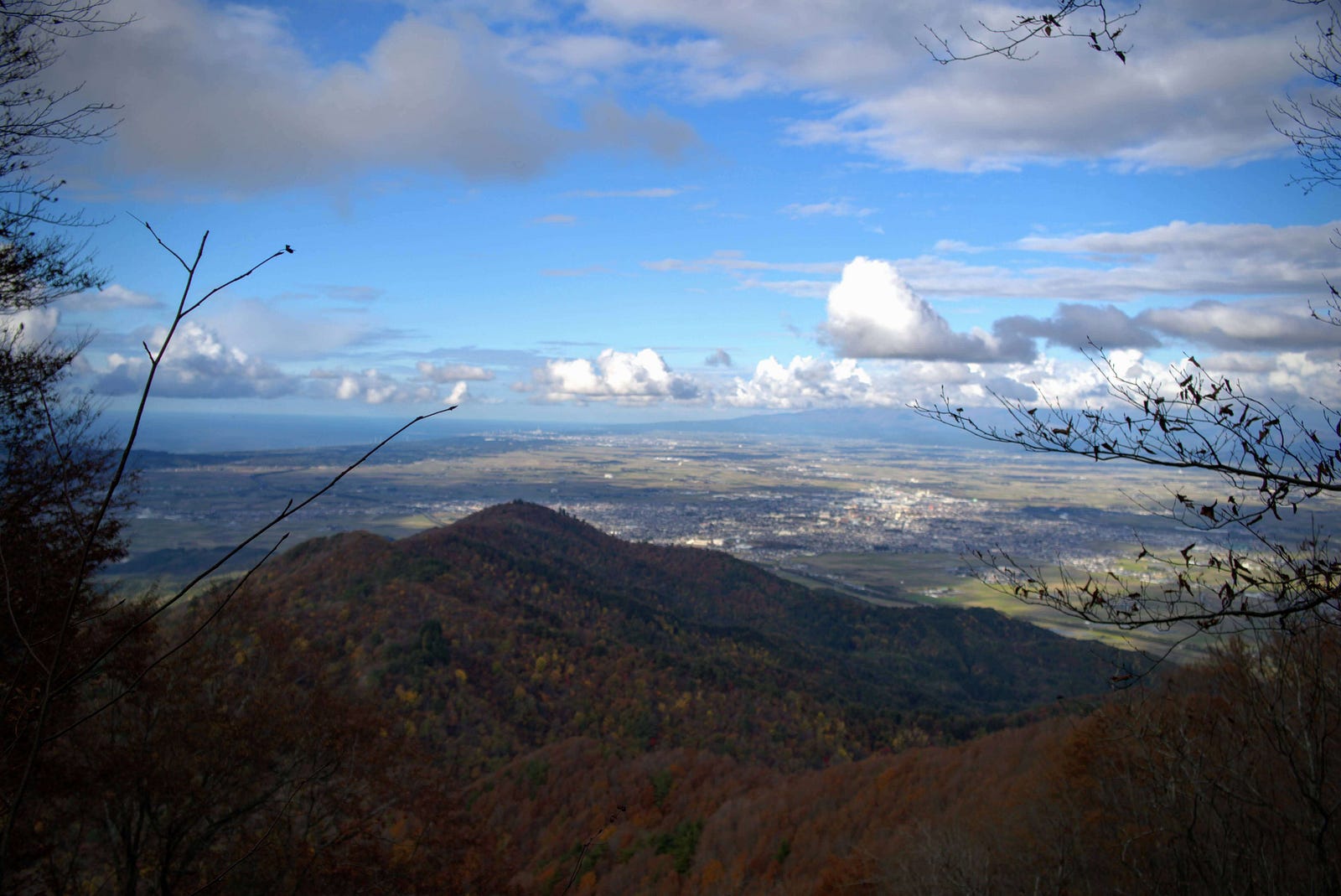 The autumn leaves of Mt. Kinbo and Mt. Yorogamine, Tsuruoka City, and the Shonai coast of The Sea of Japan seen from Mt. Hokari