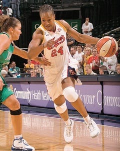 Catchings dribbles the basketball and is wearing a jersey with number 24 on it.