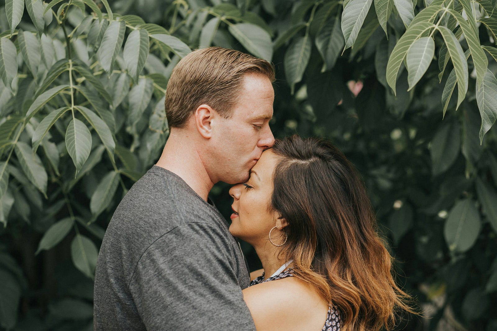 Couple embracing in a sunlit garden, symbolizing genuine human connection and affection.