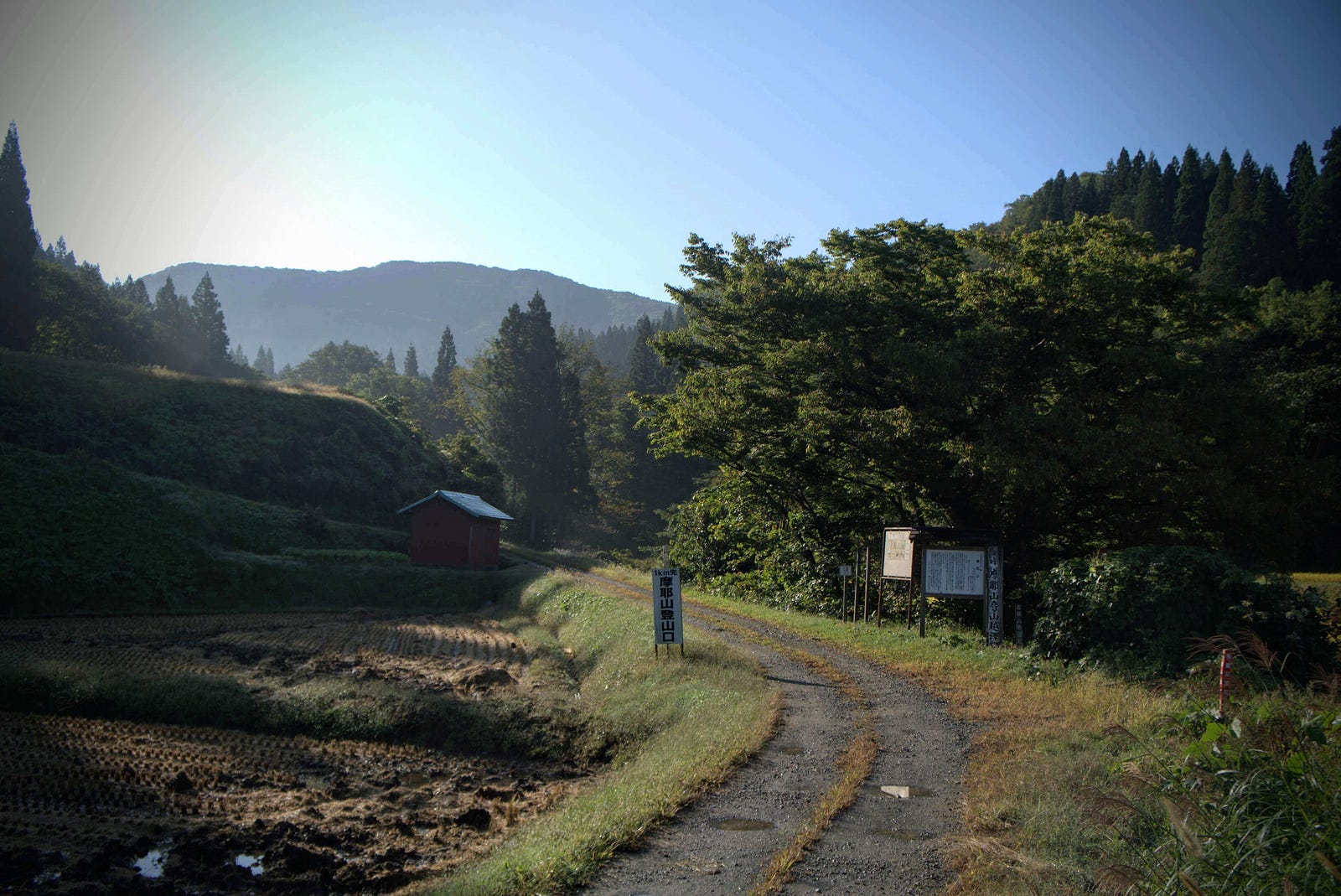 A gravel road heads towards Mt. Maya at the entrance to the Koesawa Trailhead along Road 345 heading south from central Tsuruoka to Sekigawa.