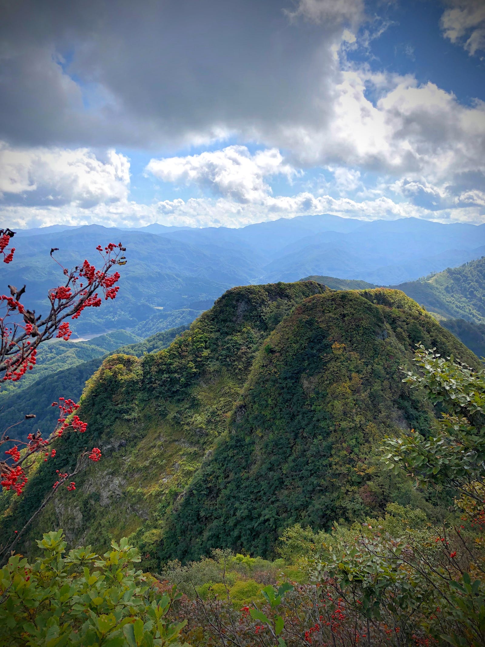 The leaves of Mt. Maya are only starting to change in early autumn on two mountains in the foreground