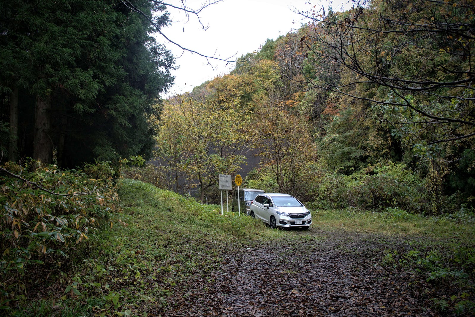 Two cars parked at the end of the gravel road at the Tanisada Trailhead to Mt. Hokari.