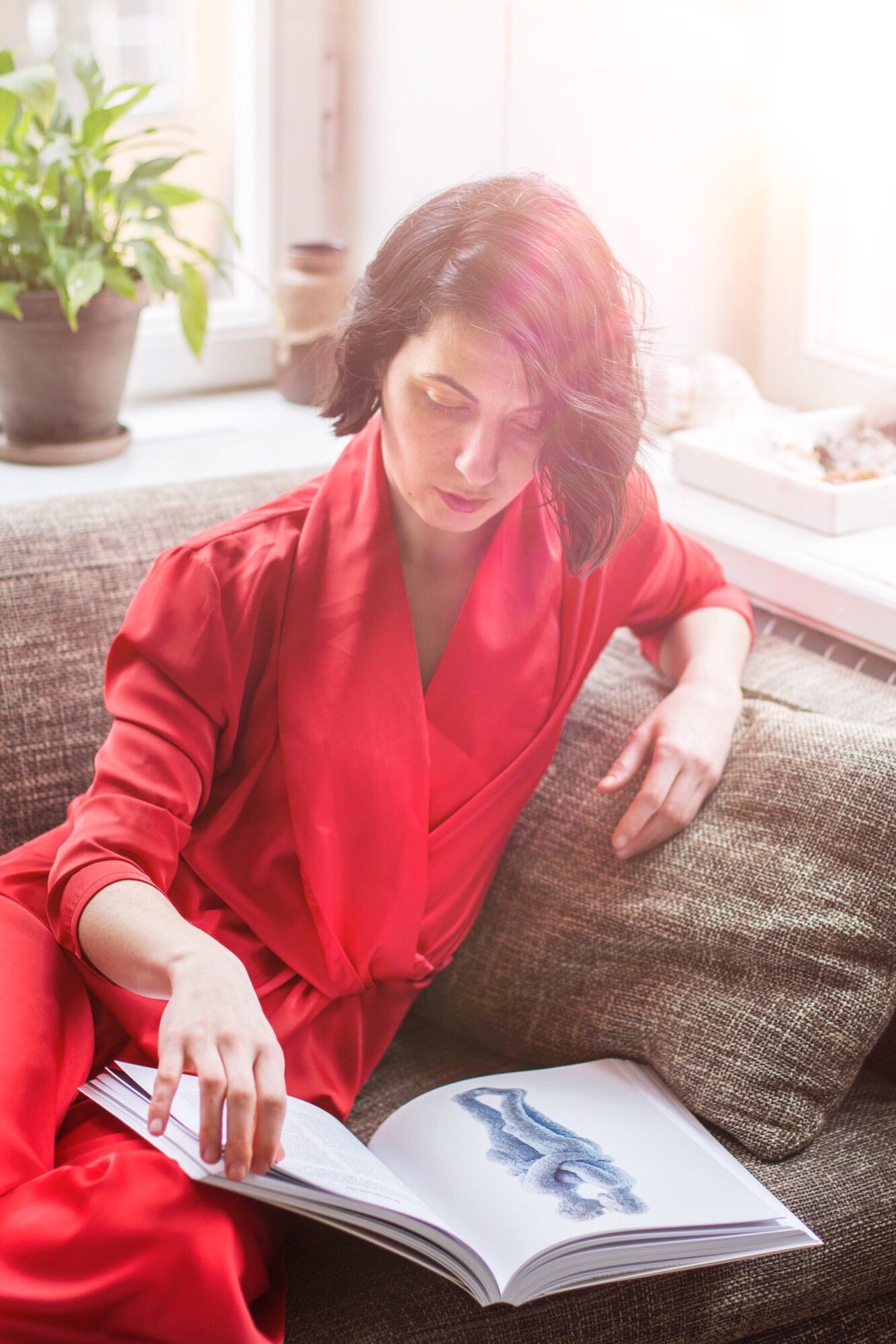Nena Stojova, the founder of Bare Origin is wearing a custom-made red silk jumpsuit by Bastet Noir
