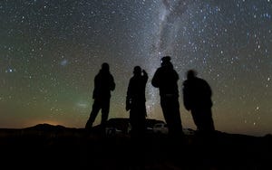 Four folks look up at the night sky.