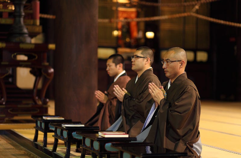 A trio of Buddhist monks recite sutras at a temple in Japan