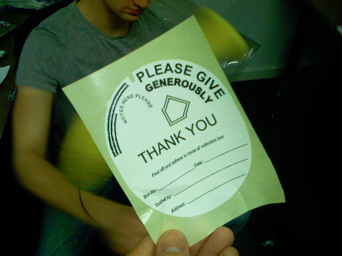 A large envelope with the text "Please Give Generously" printed on the side