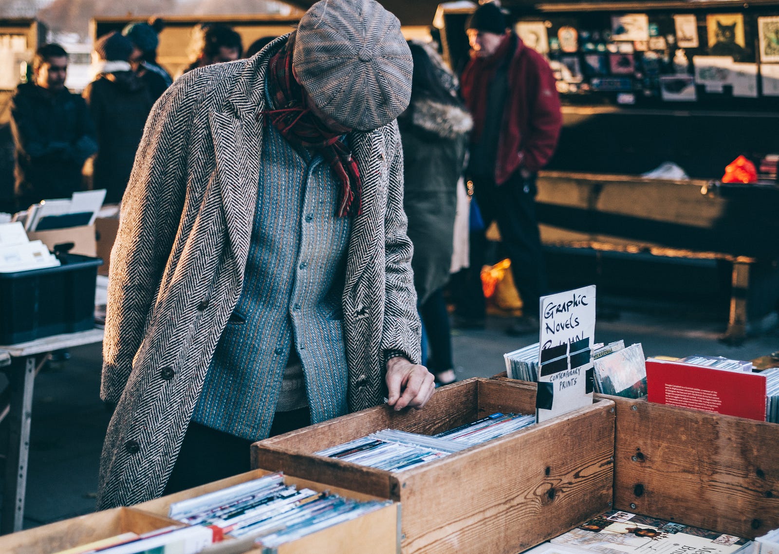 Man looking in a box at a flea market.