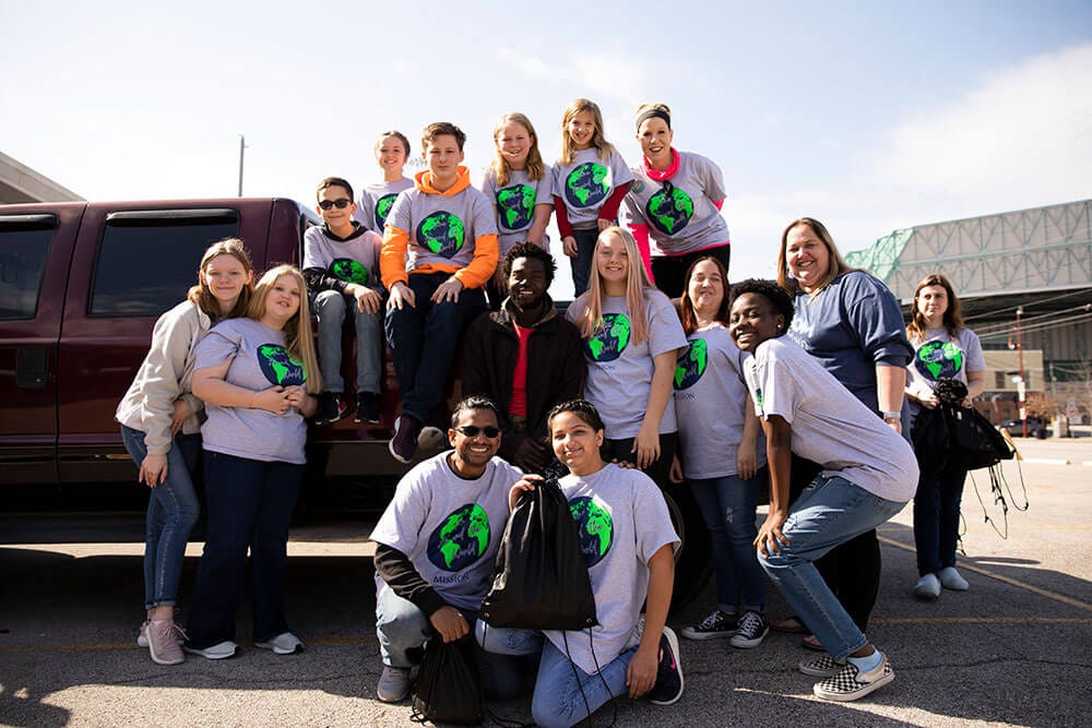 Group of volunteers posing in front of a truck