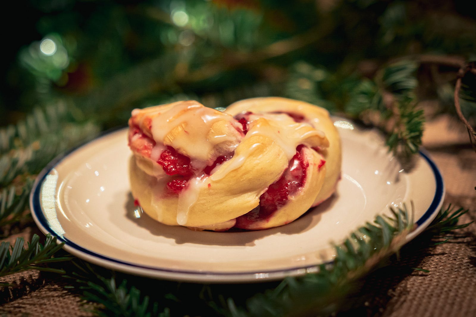 An up close view of a Pastry with a christmas tree and twinkle lights in the background.