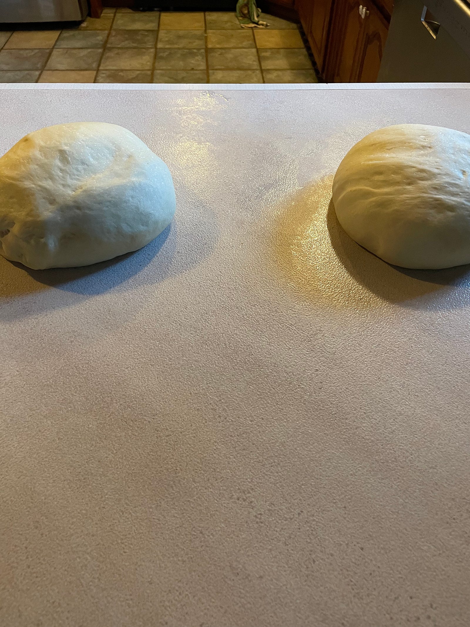 Two balls of dough on the countertop.