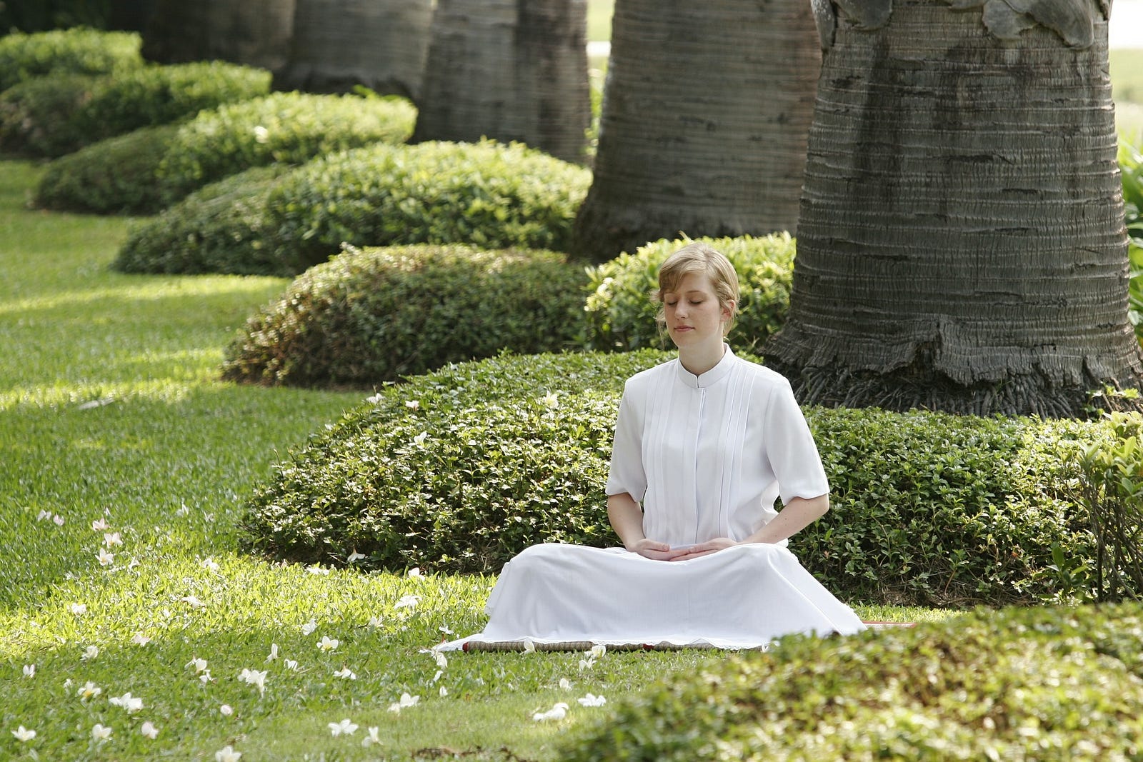 A girl sitting on grass in a meditative posture