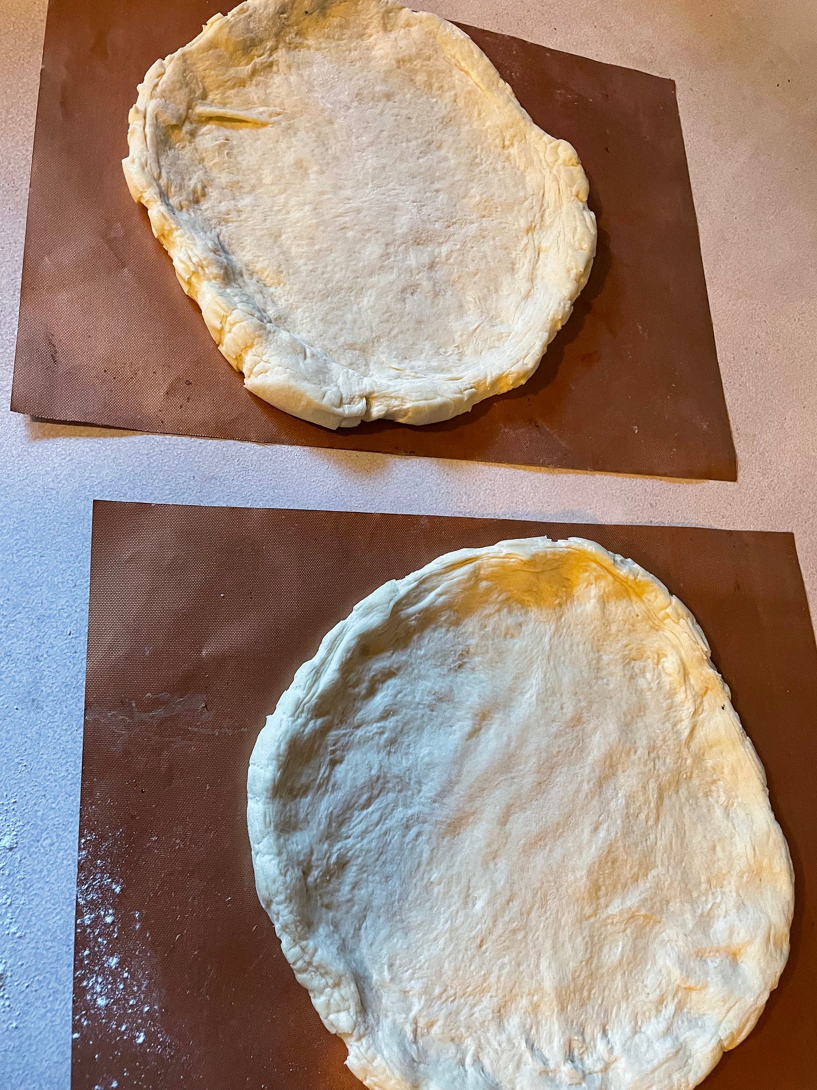 Two pizza crust dough ready for toppings.