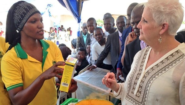 Feed the Future Uganda Youth Leadership for Agriculture agripreneur Fatuma Namatosi, left, explaining Byeffe’s pumpkin-based products to U.S. Ambassador Deborah Malac, right, at a youth fair in Mbale, Uganda. /Byeffe