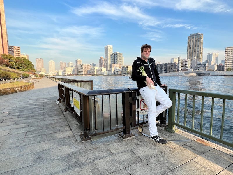 Donny Kimball stands in Tokyo’s Tsukiji area and holds a daikon, a metaphor for loving Japan