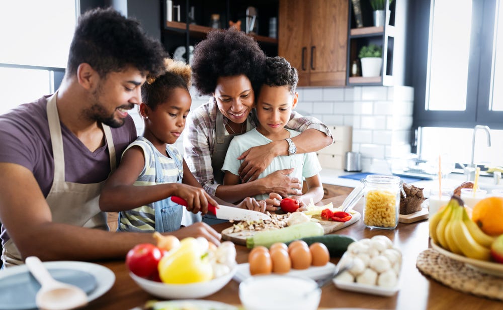 A happy family cooking together with herbs.