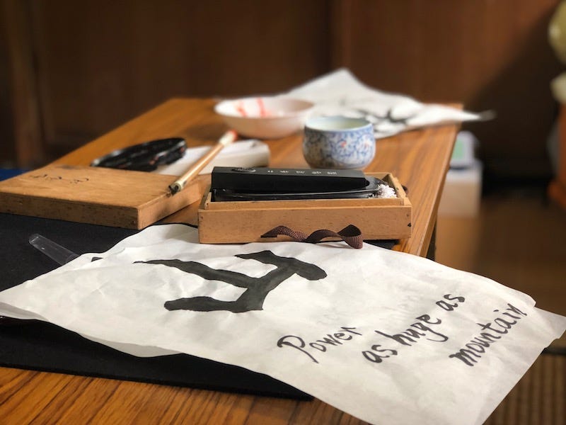 Tour paricipants practice writing the kanji for Takeda Shingen’s slogan, fu-rin-ka-zan