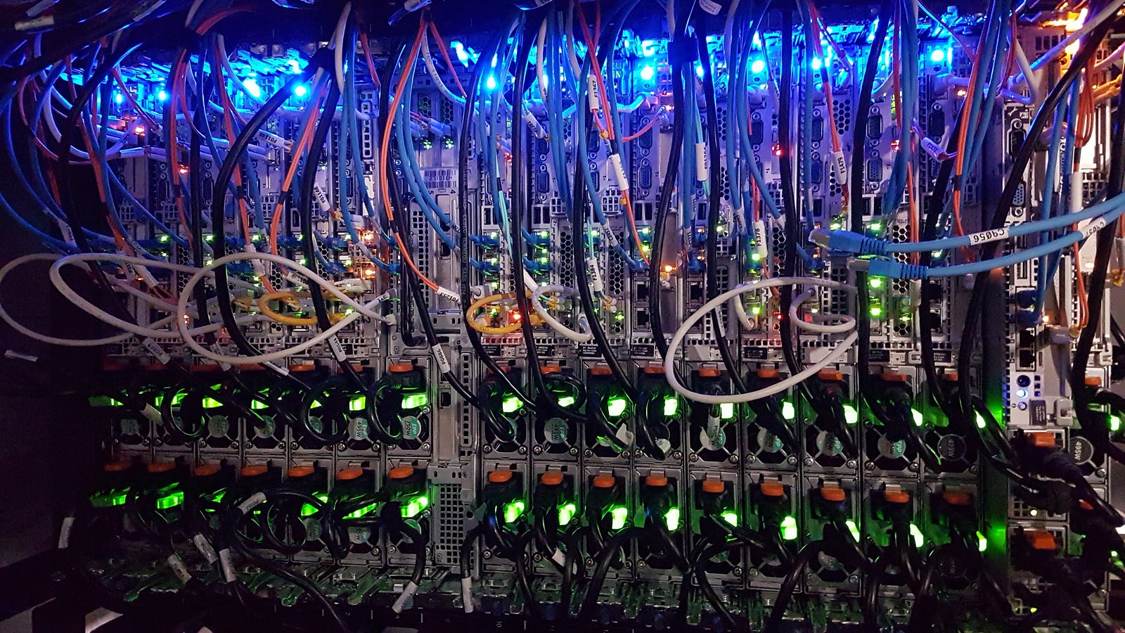 File verticali di server visti da dietro, con cavi e connessioni