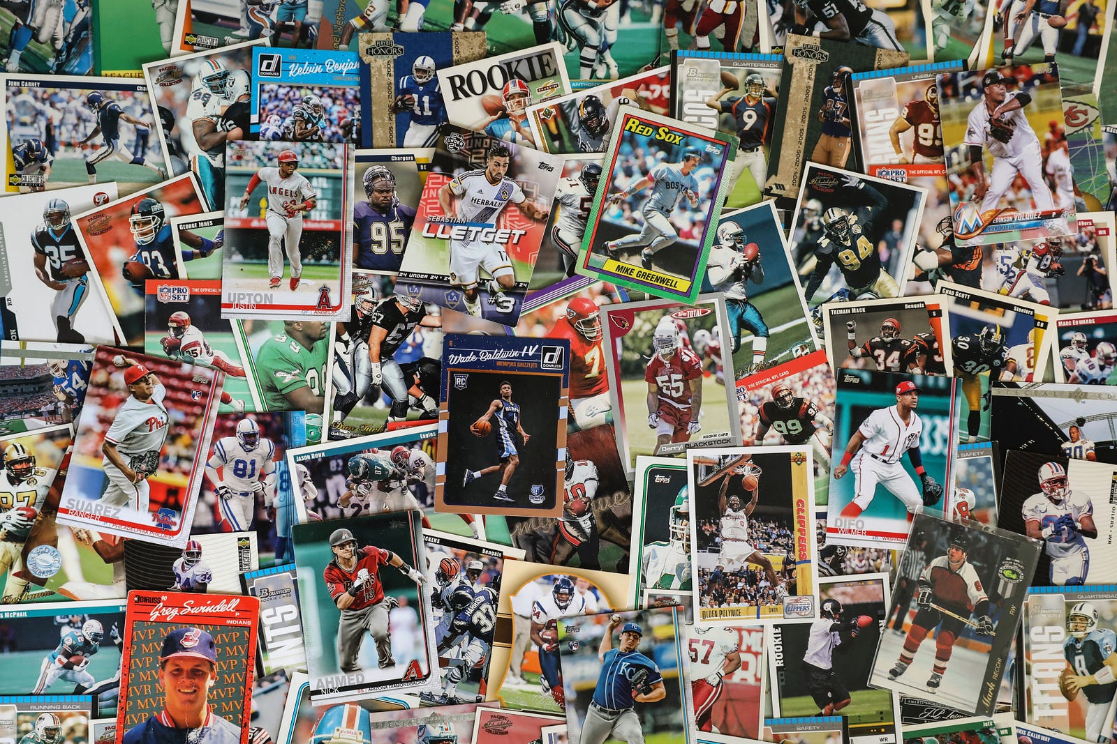 Various sports trading cards spread out on a surface.
