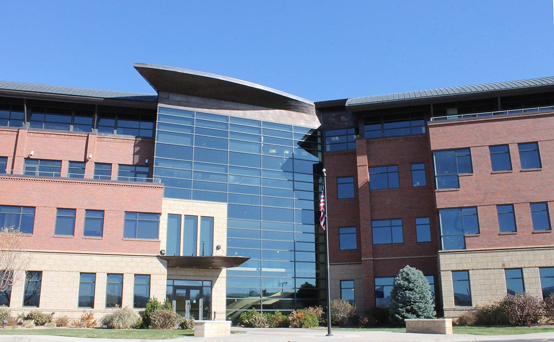 A modern 3 story office building with glass and brick.