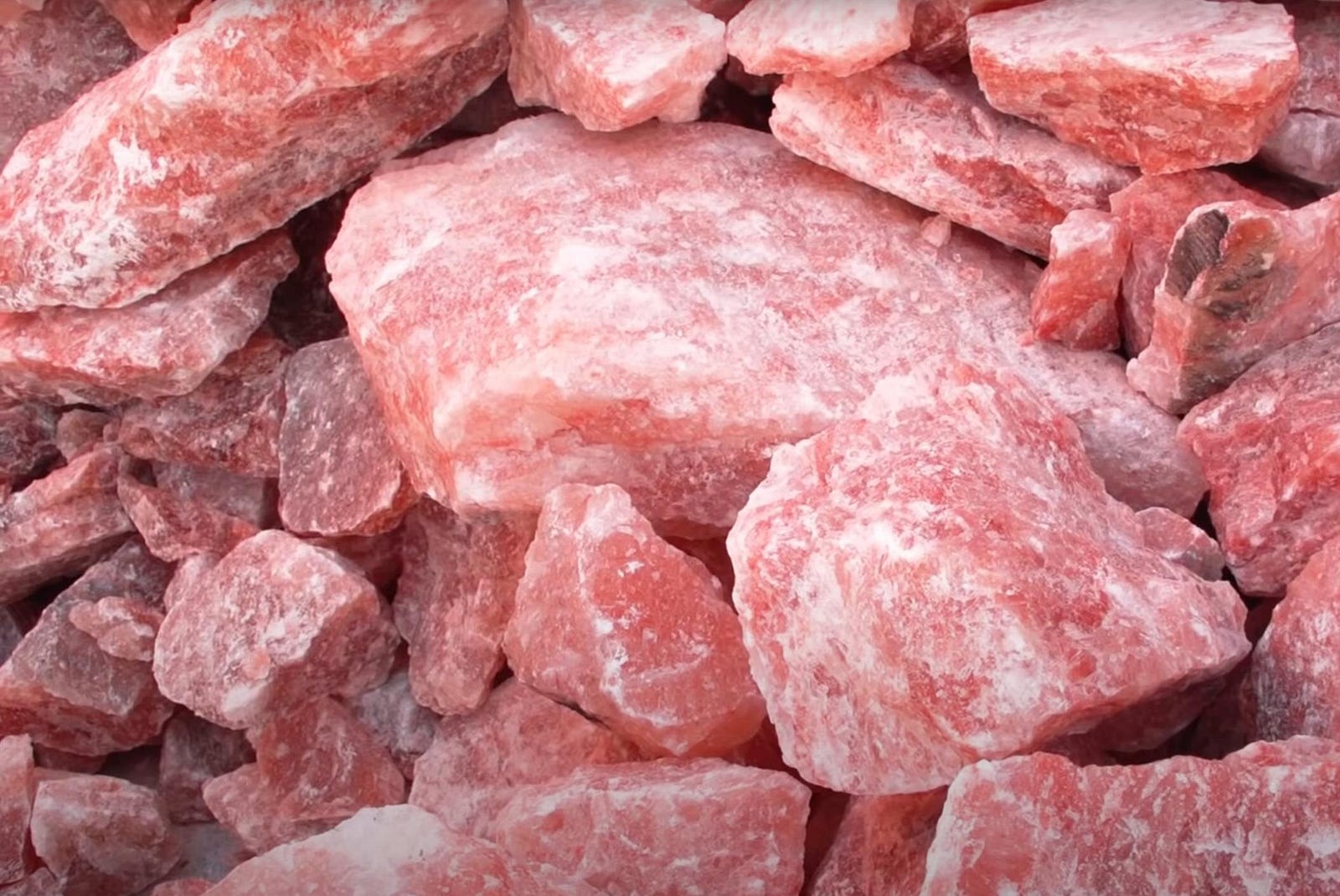 Close-up view of raw Himalayan pink salt crystals, showcasing their distinctive rosy hue and crystalline structure.