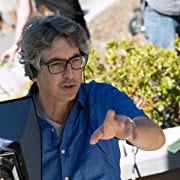 Alexander Payne on set, wearing a blue shirt and glasses, pointing his finger.