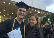 Author with diploma at college graduation with spouse