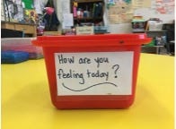 Container that reads “How are you feeling today?” in a classroom.