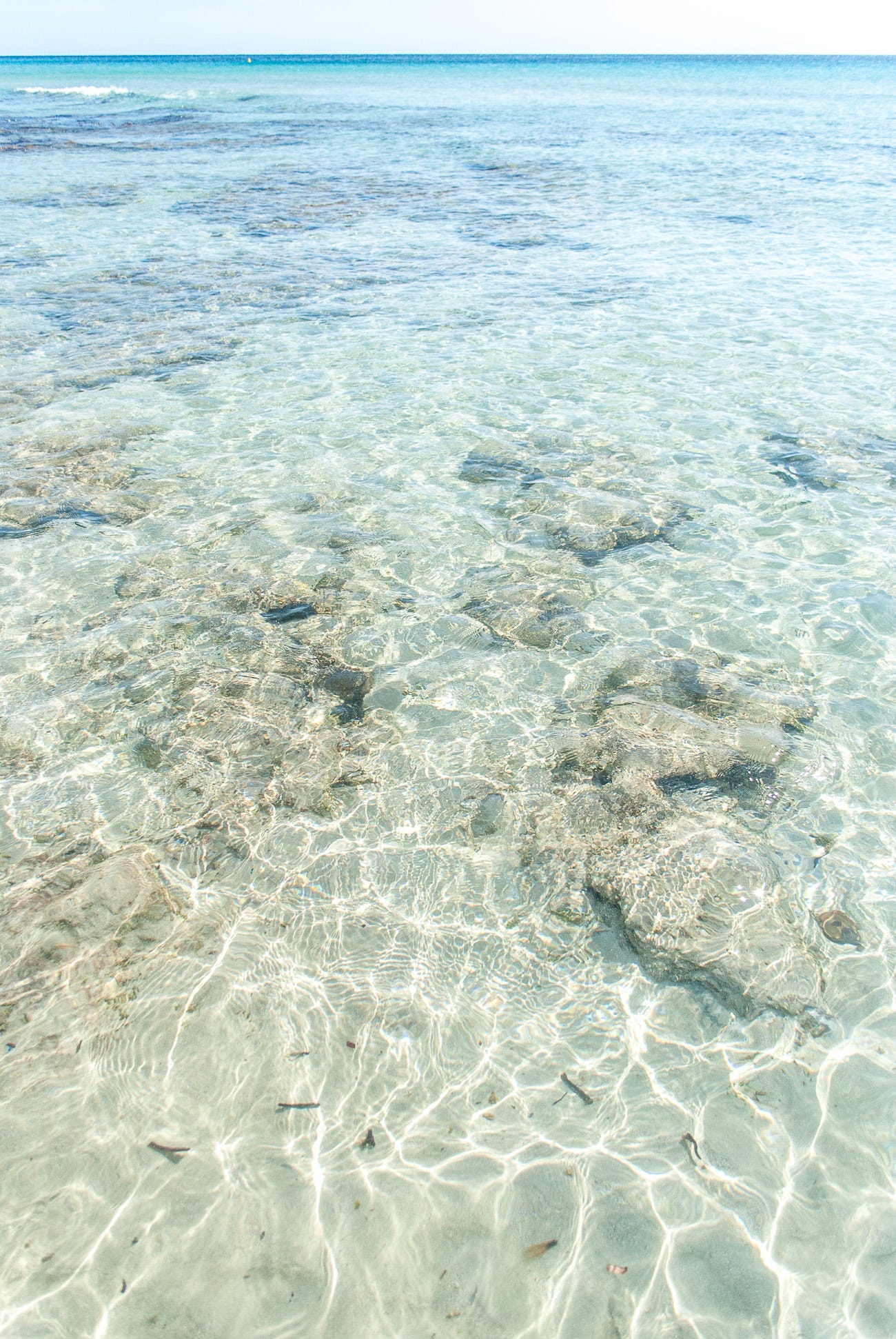 La distesa di mare azzurro e trasparente e una piscina uno dei mari pi¹ belli di Minorca ¨ rotta solo da un isolotto di rocce che dona carattere al