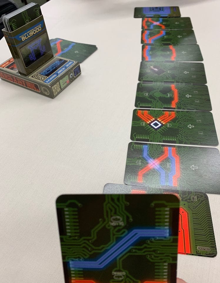 This 2-player game called RESISTOR_ allows 2-players to try and connect wires and paths to one another. It is a unique game because i’m playing with the front of the cards I have but also the backs of the cards of the other player. It uses memory in ways I haven’t seen before.