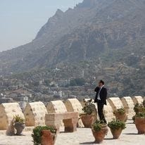 A man stands on the phone on top of a castle in Yemen