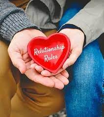 Husband Wife hold the heart on which “Relationship Rules” Written