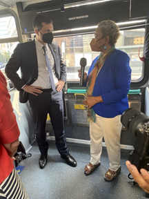 Secretary Buttigieg talks with Congresswoman Barbara Lee while riding a bus in Oakland.