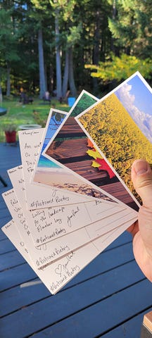 a fan of postcards, some face up showing fragments of poems, others face down showing nature scenes.