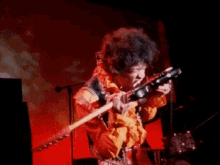 GIF of Jimi Hendrix playing guitar with his teeth