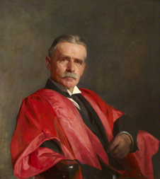 Portrait of Sir George Still reclining in chair wearing red gown.