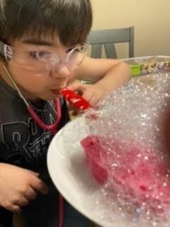 Student wearing clear work goggles and stethoscope using Balma Health COVID-19 Lung Model Kit.