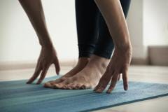 Hands by feet in yoga pose