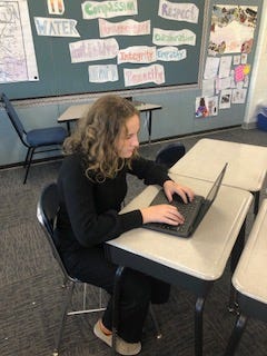 Student typing on computer.